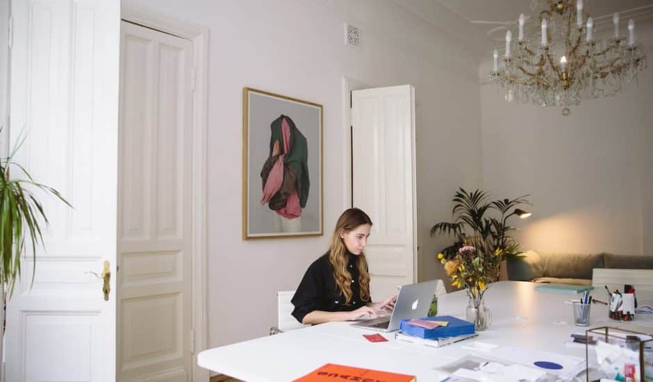 une femme assise devant un bureau sur son ordinateur
