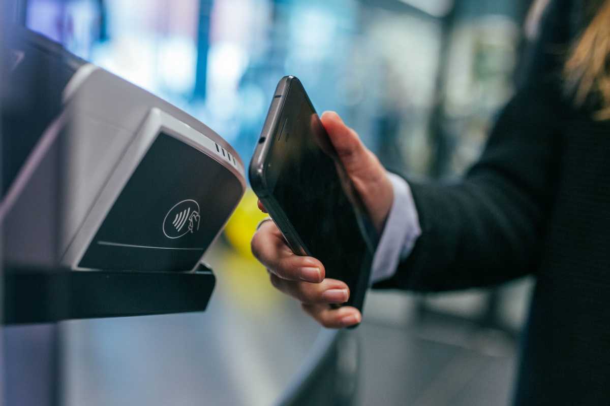 Une personne utilisant son smartphone pour réaliser un paiement.