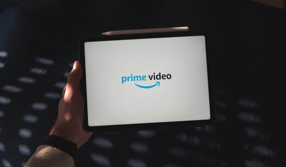 Une personne tenant une tablette diffusant un content Amazon Prime Video.