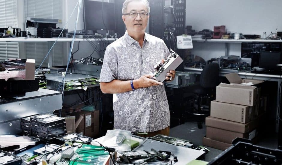 Un homme dans un bureau de maintenant informatique tenant un composant éléctronique.