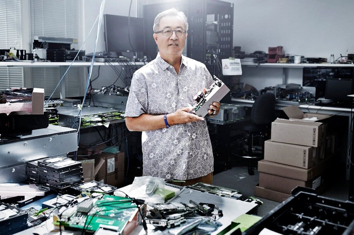 Un homme dans un bureau de maintenant informatique tenant un composant éléctronique.