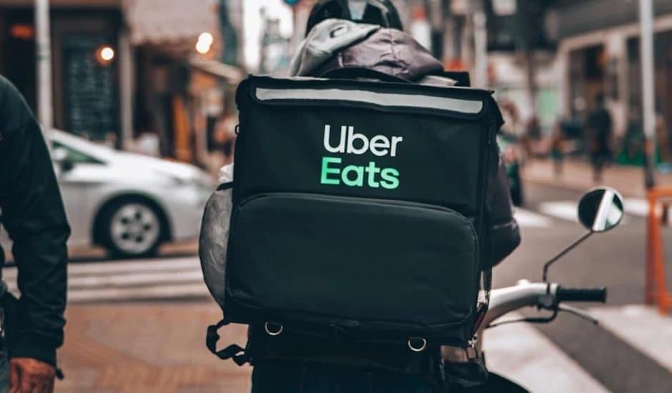 Un livreur Uber Eats à vélo photographié de dos